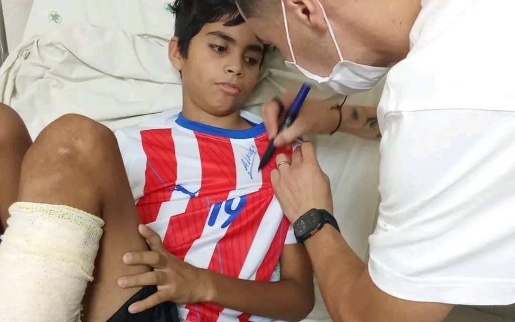 Almirón firmando autógrafo de un niño en el hospital
